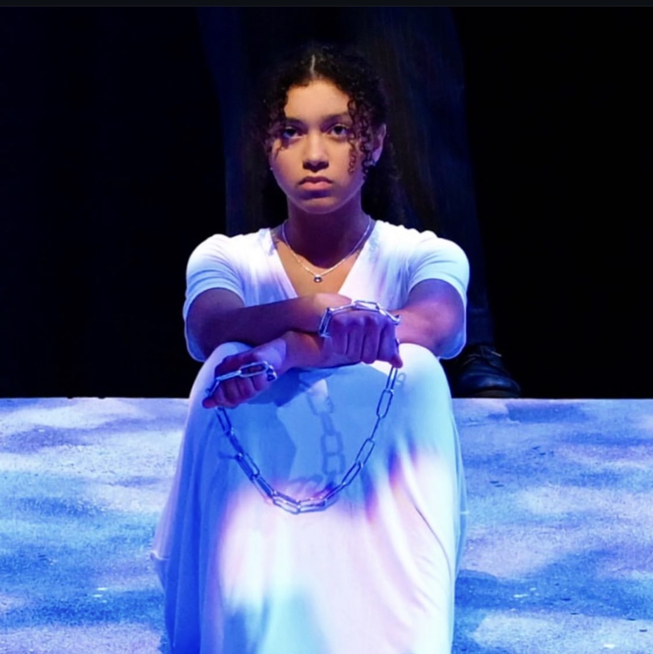 Ariana Barbosa performing on stage in Antigone